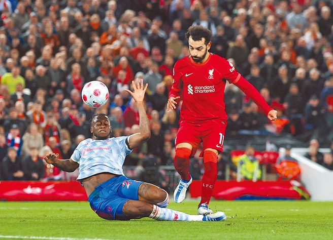 利物浦射手萨拉（右）起脚射门，球碰到曼联后卫汪比萨卡的脚折射入网。（路透）